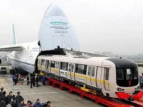 A train carriage being loaded into a cargo plane