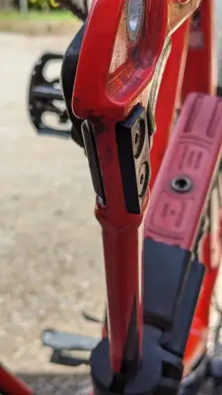 close-up picture of the bottom of the rear seat stay (upside down, with the dropout at the top of the picture) showing bolt holes on the rack adaptor
