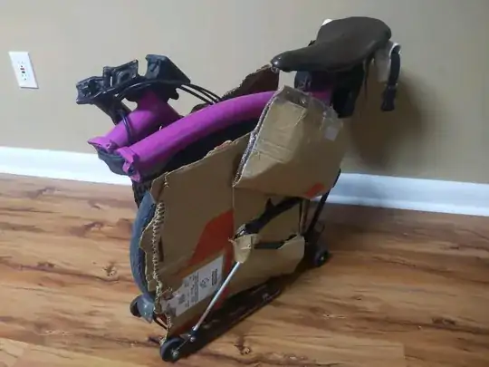 photo of a folded brompton with cardboard covering its hinges, pedals, and spokes