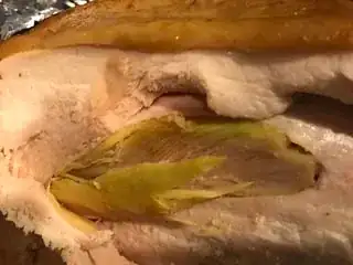 Yellow-green fiber-looking meat inside regular cooked chicken breast