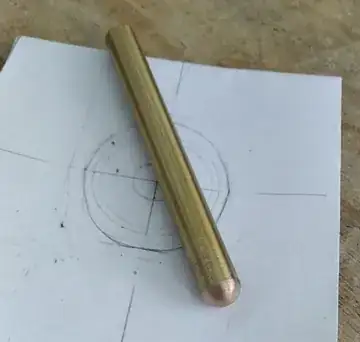 A metal rod with original golden body and a tip turned coppery