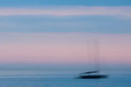 soft blue sea and sky with the blurred silhouette of a boat