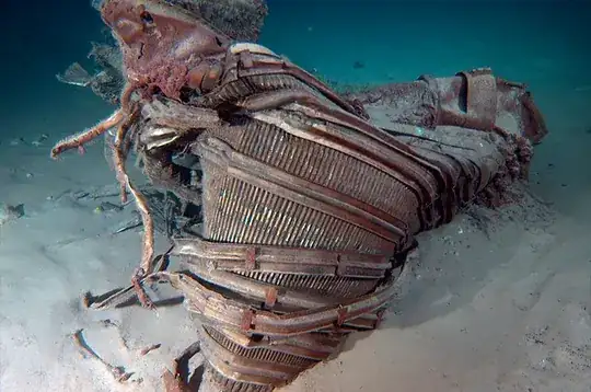 brazed tubing and barrel hoops of F-1 engine nozzle, twisted and deformed, half buried in sand on ocean floor