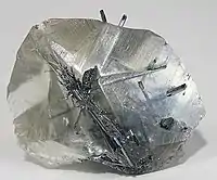 Needles of stibnite within a transparent crystal of calcite (size: 4.5×3.5×1.8&nbsp;cm)