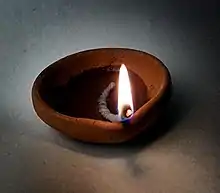 A small bowl with a lighted wick in it